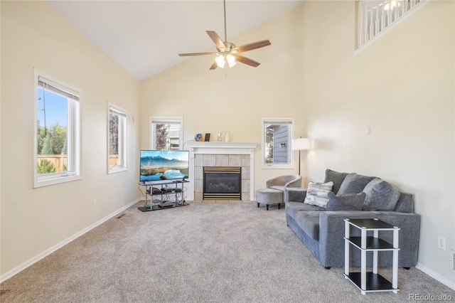 living room with a tile fireplace, carpet flooring, ceiling fan, and high vaulted ceiling