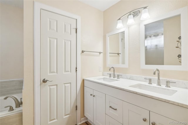 bathroom featuring vanity and a tub