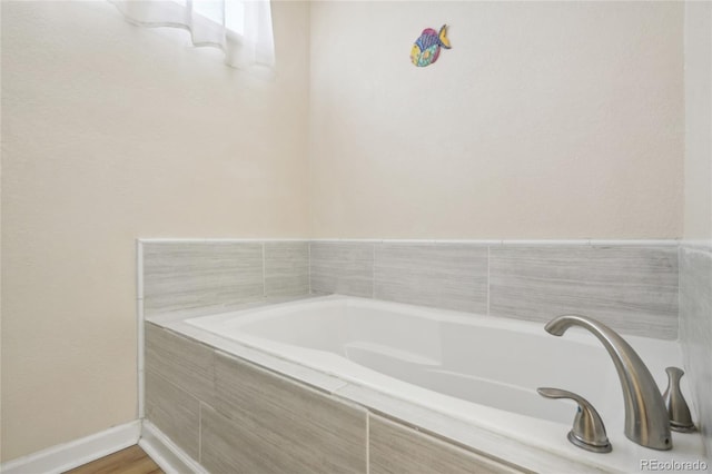 bathroom featuring tiled tub