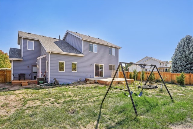 rear view of house with a deck and a lawn