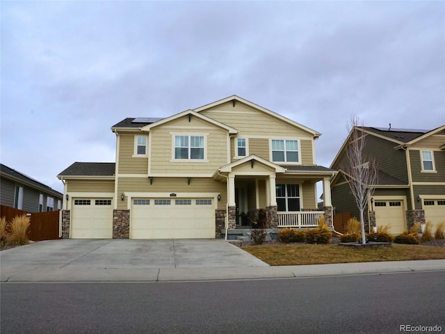 craftsman-style home with a garage, solar panels, and a porch