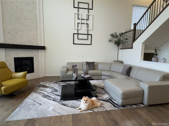 living room with dark hardwood / wood-style floors and a large fireplace