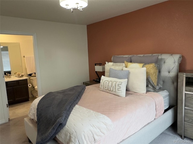 bedroom with light colored carpet and ensuite bath