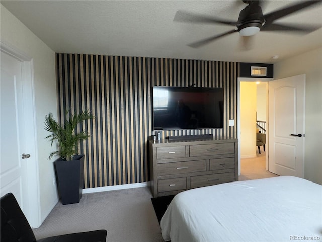 carpeted bedroom with ceiling fan and a textured ceiling