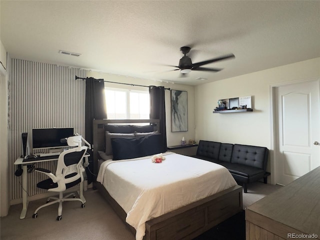 bedroom with ceiling fan, a textured ceiling, and carpet flooring