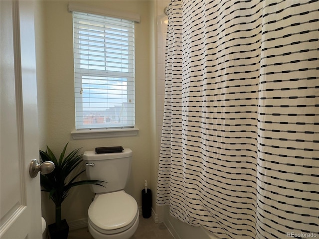 bathroom featuring toilet and shower / tub combo with curtain