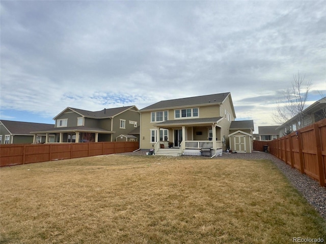 rear view of house featuring a lawn and a storage unit