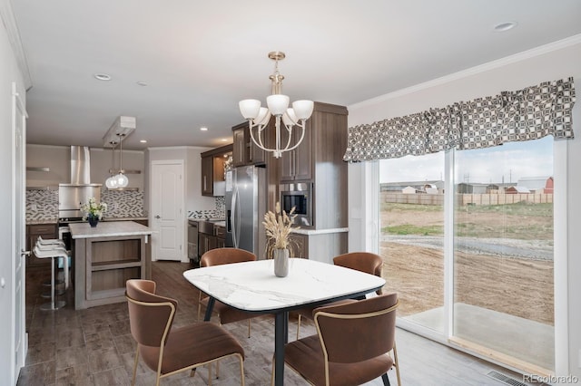 dining space with an inviting chandelier and ornamental molding