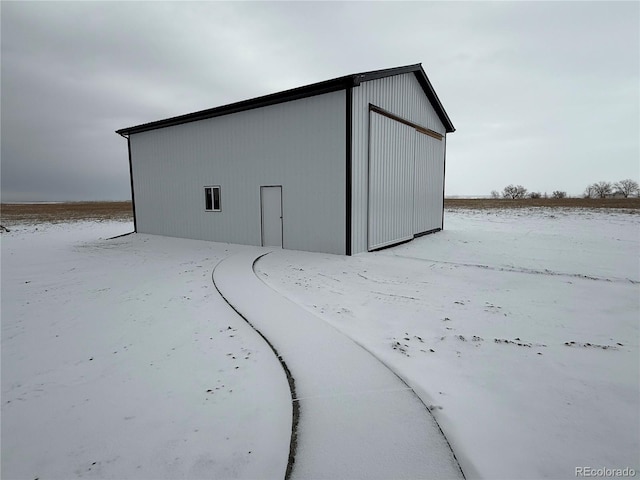 snow covered structure with a garage