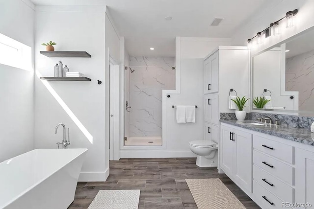 full bathroom with hardwood / wood-style flooring, shower with separate bathtub, vanity, and toilet