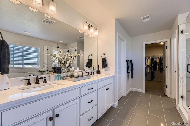 7253 S Valleyhead Ct, Aurora, CO 80016 - full bathroom with a stall shower, double vanity, tile patterned floors, and a spacious closet