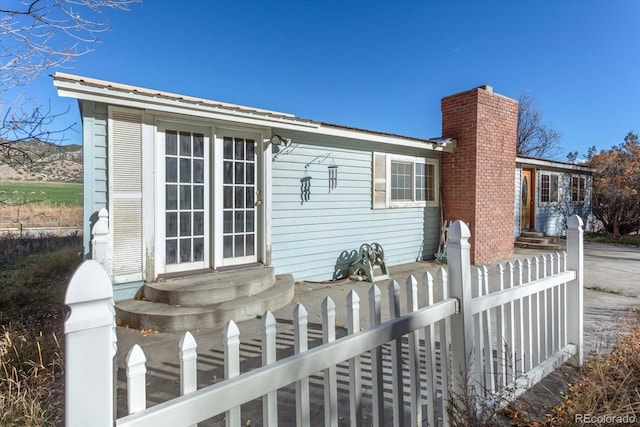 7032 County Road 156c, Salida, CO 81201 - back of house with fence private yard, entry steps, and a chimney