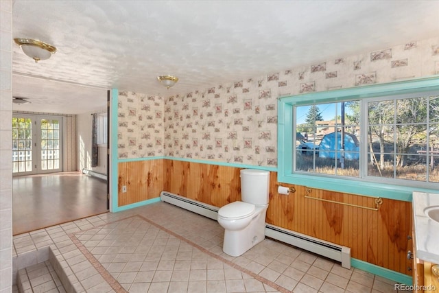 bathroom with tile patterned flooring, baseboard heating, and french doors