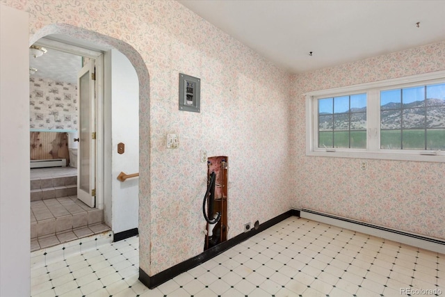 7032 County Road 156c, Salida, CO 81201 - spare room with arched walkways, wallpapered walls, baseboards, and baseboard heating