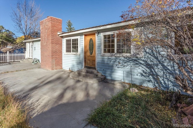 7032 County Road 156c, Salida, CO 81201 - view of front of home featuring fence, a chimney, entry steps, and a patio