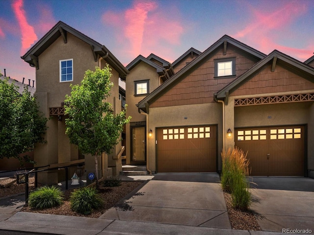 11962 W Long Cir Unit 203, Littleton, CO 80127 - view of front facade with driveway, stucco siding, and a garage