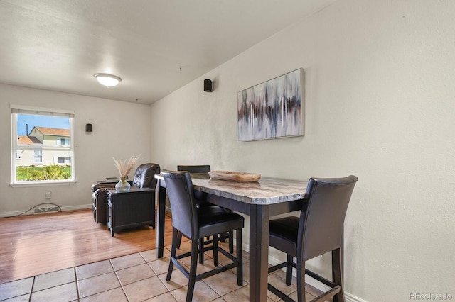 dining space with baseboards and light tile patterned floors