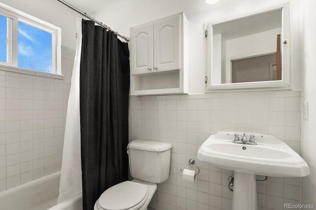 bathroom featuring tile walls, shower / bath combo, and toilet