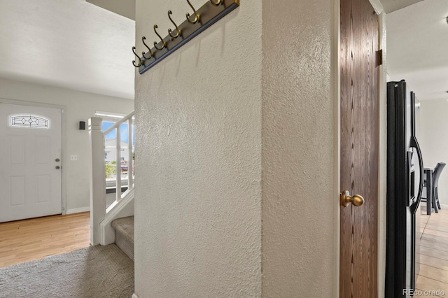 10645 Moore Ct, Broomfield, CO 80020 - room details with baseboards, a textured wall, black fridge with ice dispenser, and wood finished floors