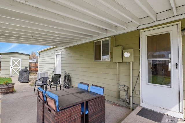 view of patio featuring a storage shed, an outbuilding, and central air condition unit