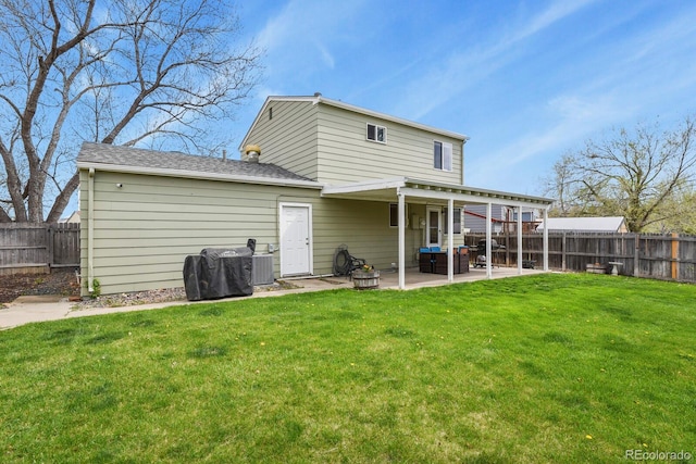 rear view of property with a lawn, central AC unit, a fenced backyard, and a patio area