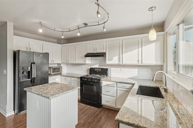 6307 Monterey Pl, Highlands Ranch, CO 80130 - kitchen with black appliances, under cabinet range hood, a sink, white cabinetry, and tasteful backsplash