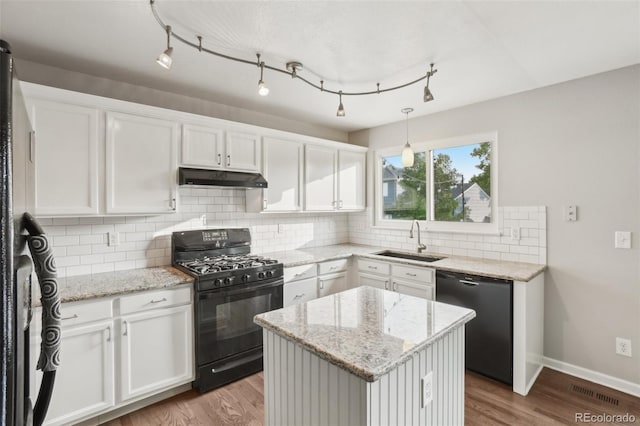 6307 Monterey Pl, Highlands Ranch, CO 80130 - kitchen featuring black gas stove, dishwasher, a sink, under cabinet range hood, and white cabinetry