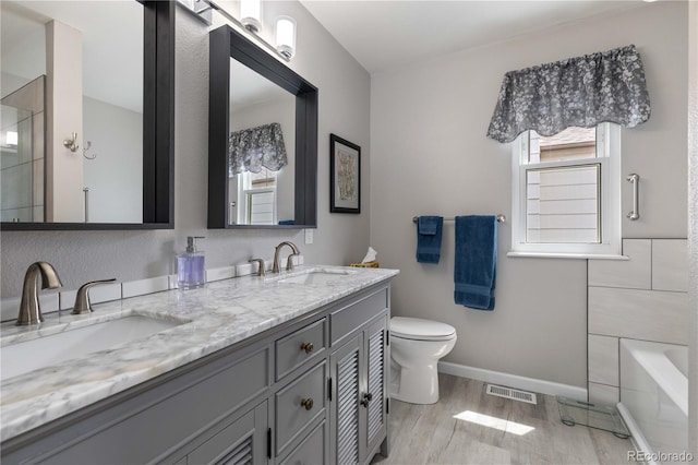 6307 Monterey Pl, Highlands Ranch, CO 80130 - bathroom with toilet, wood finished floors, double vanity, a bath, and a shower