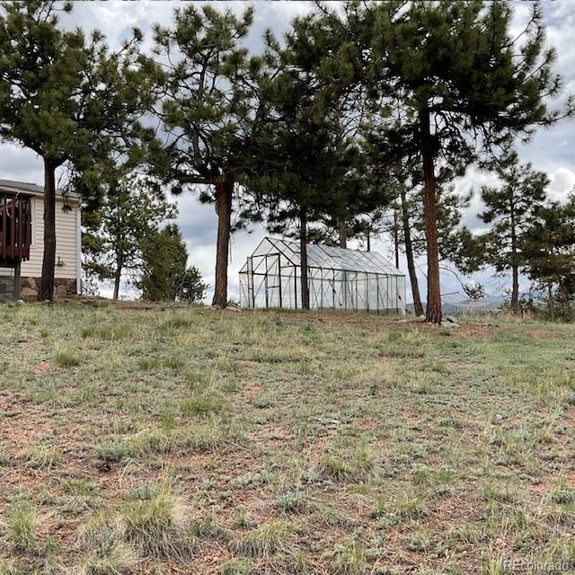 696 Calle De La Nieva, Florissant, CO 80816 - view of yard featuring a greenhouse and an outdoor structure