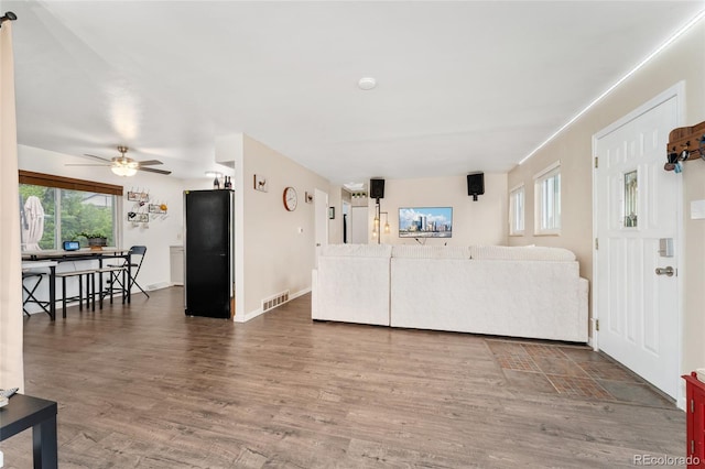 living room with plenty of natural light, a ceiling fan, and wood finished floors