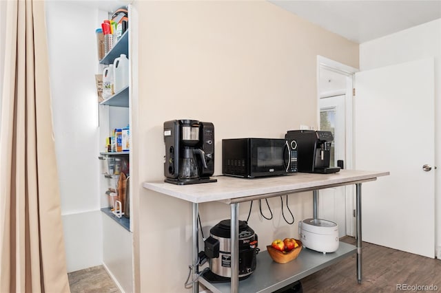 kitchen with black microwave and wood finished floors