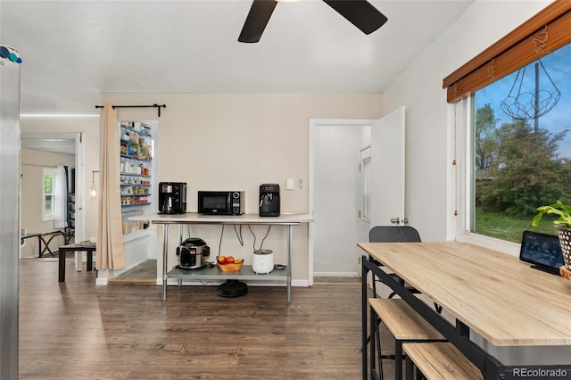 dining space featuring a ceiling fan, wood finished floors, and baseboards