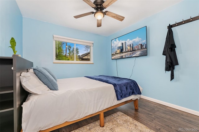 bedroom featuring wood finished floors, baseboards, and a ceiling fan