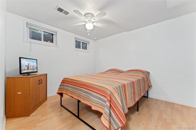 bedroom featuring light wood finished floors, ceiling fan, and baseboards