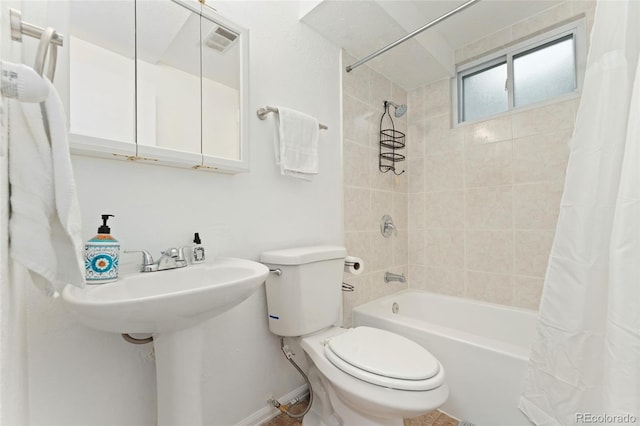 full bath with toilet, shower / tub combo, and baseboards