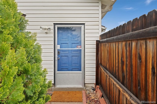 doorway to property featuring fence