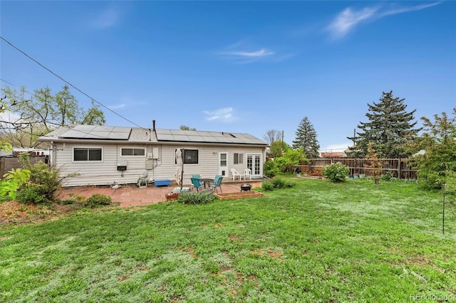 back of property featuring a patio, roof mounted solar panels, and french doors
