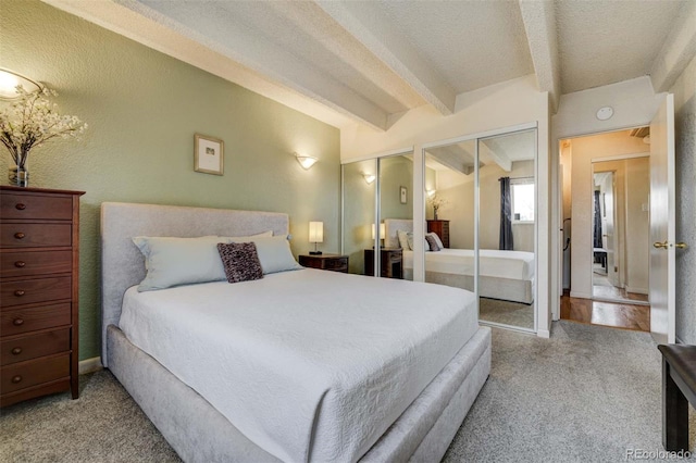 carpeted bedroom with multiple closets, a textured ceiling, and beam ceiling