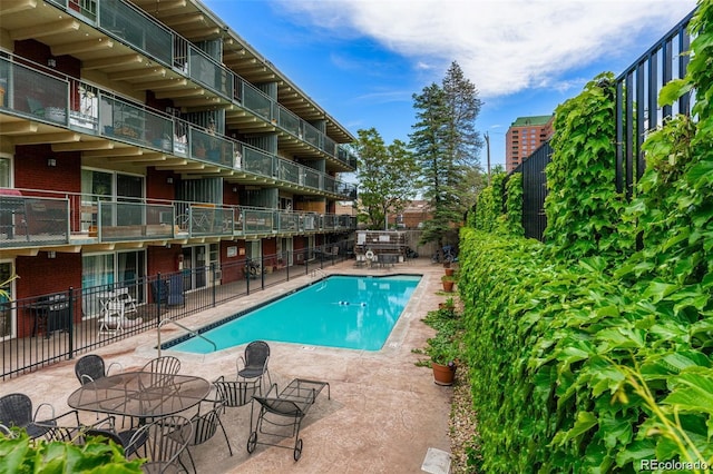 pool with fence and a patio area