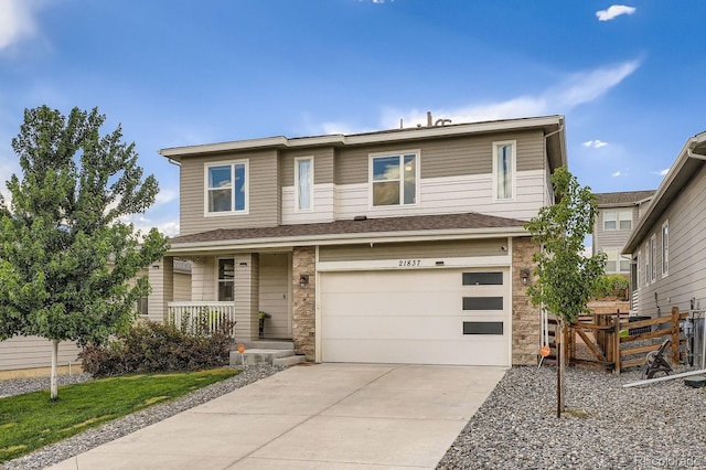 21837 E Stanford Cir, Aurora, CO 80015 - view of front of house featuring covered porch, concrete driveway, a garage, and stone siding