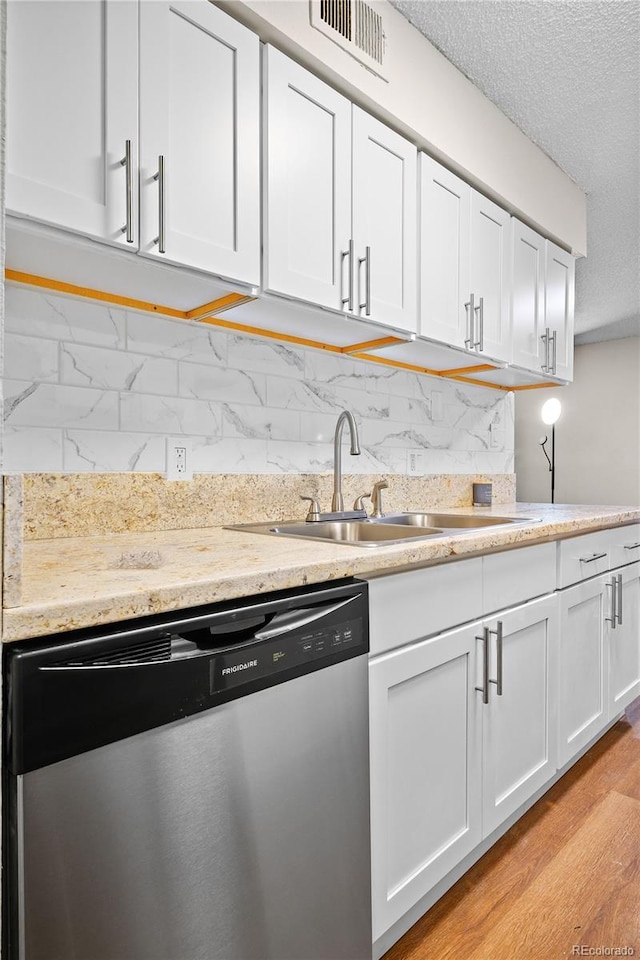 kitchen featuring sink, light hardwood / wood-style floors, white cabinets, and dishwasher