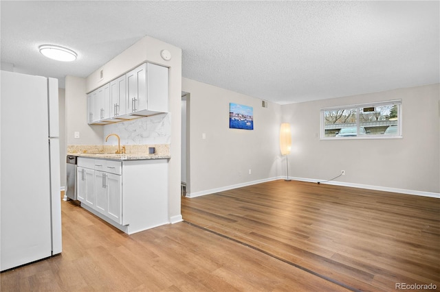 kitchen with dishwasher, sink, white cabinets, white refrigerator, and light hardwood / wood-style floors