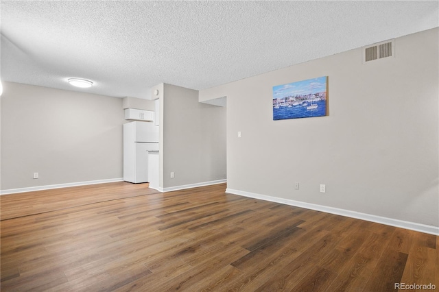 unfurnished room with wood-type flooring and a textured ceiling