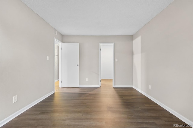 spare room featuring dark wood-type flooring