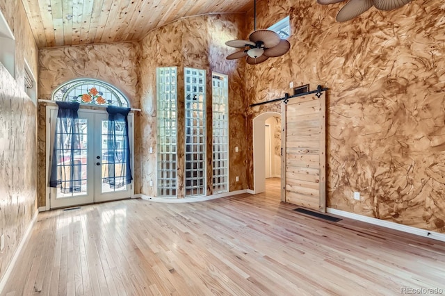 spare room with french doors, wood ceiling, ceiling fan, a barn door, and high vaulted ceiling