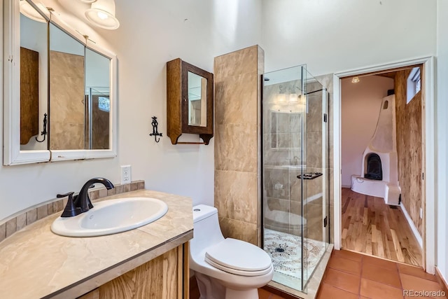 bathroom with tile patterned floors, vanity, toilet, and a shower with shower door