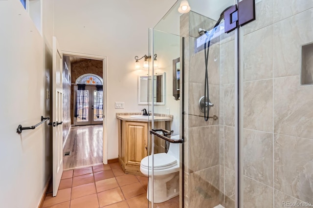 bathroom featuring vanity, french doors, tile patterned floors, toilet, and an enclosed shower