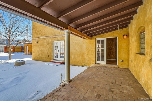 snow covered patio featuring french doors