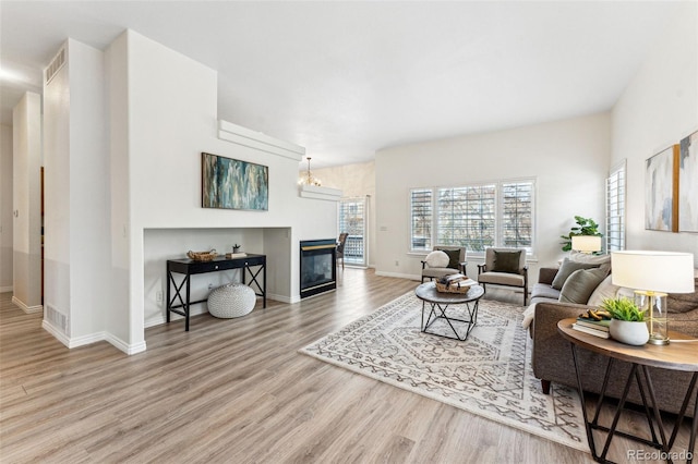 living room with a chandelier and light hardwood / wood-style floors