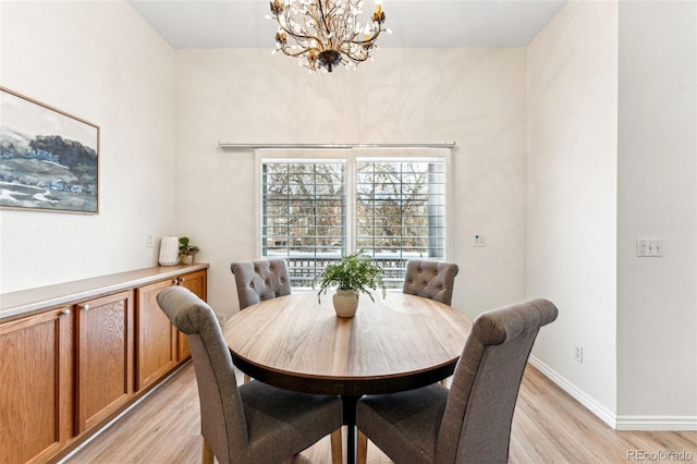 dining space featuring light hardwood / wood-style flooring and a notable chandelier